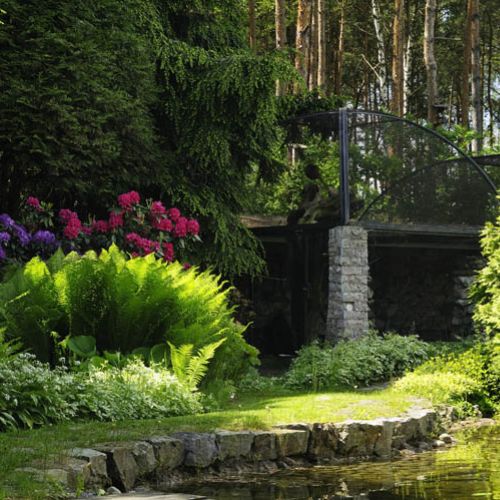 Na tyłach ogrodu tuż przy niewielkiej sadzawce jest brama zrobiona ze starych słupów telegraficznych. Prowadzi