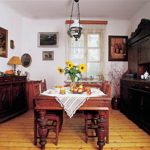 Nad stołem wisi zdobiona lampa. Nowoczesność ukryta