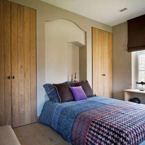 Narzutę, poduchy i rolety gospodyni przywiozła ze swojego sklepu Lefevre Interiors, a szafy i parapet-półkę