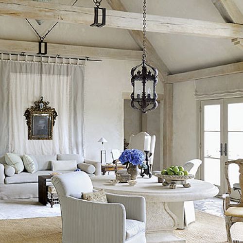 Naturalne materiały: lniane kotary, drewniane belki i kamienna podłoga.