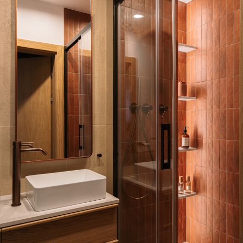 łazienka z rudymi płytkami i strukturalnym tynkiem