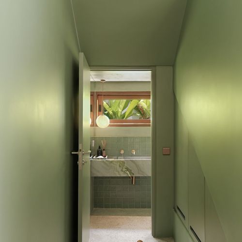 Zielona łazienka w stylu tropical modern w domu na Bali zaprojektowanym przez polską pracownię AMOK Architecture