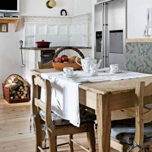 Obok nowoczesnej lodówki stary piec. W ogrodzie sztuki