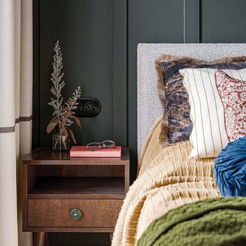 ciemny kolor ścian w sypialni i kontrastowe poduszki