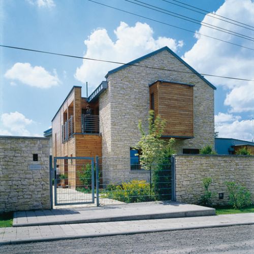 Ogrodzenie także zbudowano z wapienia, aby dobrze komponowało się z elewacją domu.