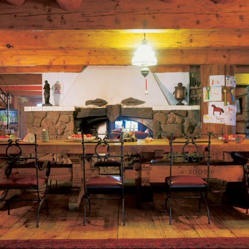 Parter domu to ogromna, przestronna izba podzielona na pół ścianą z kominkiem.