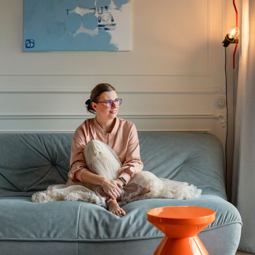 salon z pastelowoniebieską sofą i pomarańczowym stolikiem kawowym