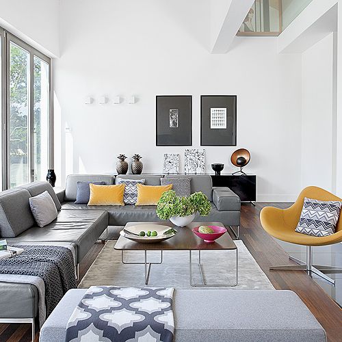 Pledy i poduszki - NAP. W oknach brak zasłon i firan, dzięki temu do salonu wpada mnóstwo naturalnego światła.