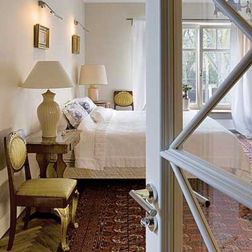 Po obu stronach łóżka na stolikach stoją lampki.