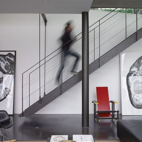 Pod zwodzonymi schodami krzesło inspirowane Mondrianem. Zaprojektował je Gerrit Rietveld w 1917 roku.