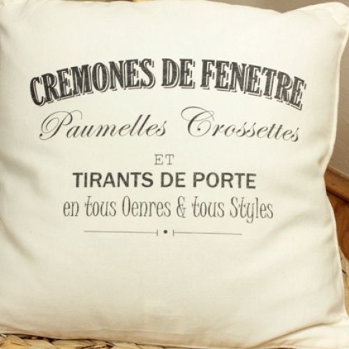 Poduszka uszyta z bawełnianej tkaniny w kolorze jasnego kremu. Przednia strona ozdobiona czarnym nadrukiem francuskiej