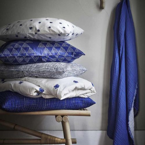 Leciutkie rattanowe fotele i ławki, kosze uplecione z morskich traw, lniana pościel w kolorze indygo,