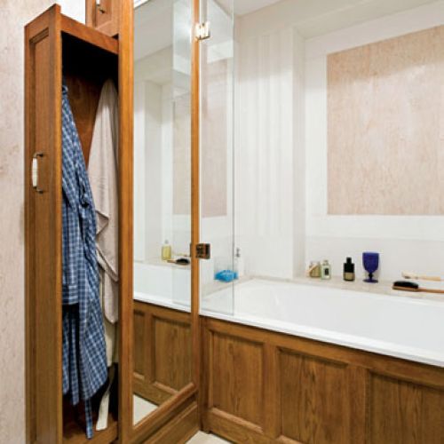 Pomysłowy schowek: za lustrem znajduje się płytka szafa na szlafrok i reczniki.