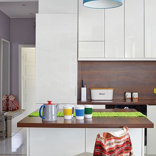 Proste białe fronty szafek bez przeszkleń - takie meble pomagają utrzymać porządek w małej kuchni.