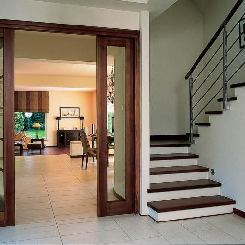 Przeszklone drzwi dzielą hol od salonu.