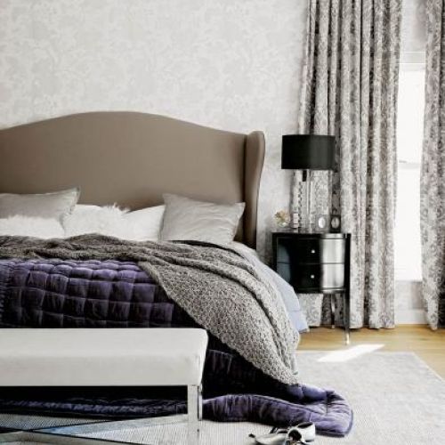 Przy łóżku stoi czarna szafeczka. Rezydencja nad stawem