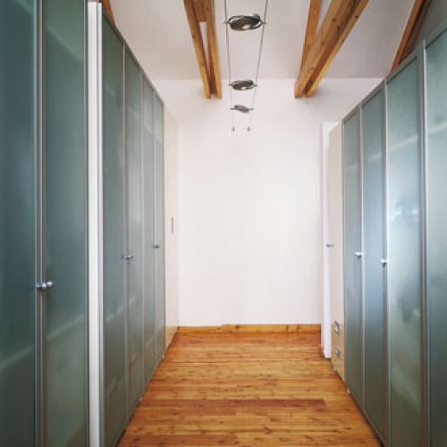 Przy najbardziej nasłonecznionej ścianie powstała garderoba, stanowiąca doskonałą izolację. Dzięki temu w upały