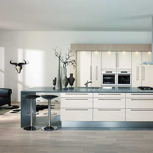 Przy wyspie znalazło się miejsce na dwa krzesła barowe. Pomalowane na biało dębowe fronty i laminaty w kolorze piaskowym