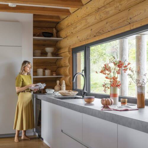 biała kuchnia z drewnem w domu z bali