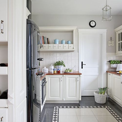 Rustykalna elegancja z pałacową posadzką i lodówką glamour. Do tego ciepłe drewno i swojskie ceramiczne