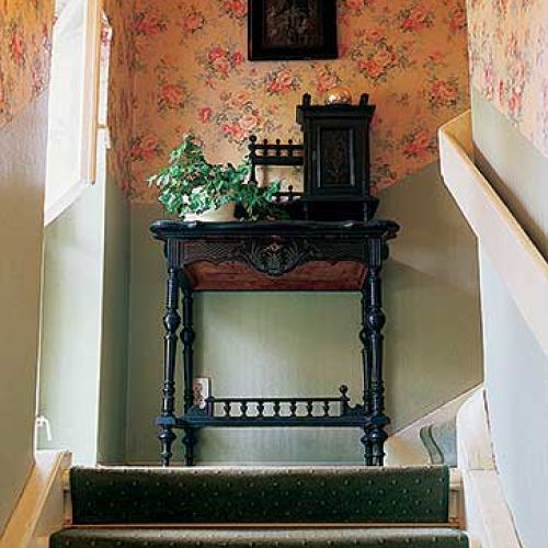 Schody otoczonekwiecistą tapetą. Willa Helena w Milanówku