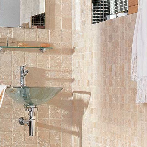 Ściana wyłożona jest trawertynem Moka (cena około 500 zł/mkw.), obok kremowa mozaika Travertino Beige (5 x 5 x 1