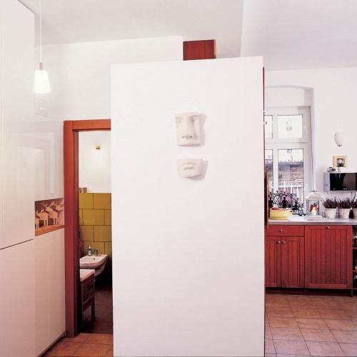 Ścianka oddzielająca kuchnię od przejścia do łazienki, nie sięga sufitu, dzięki czemu do ciemnej części