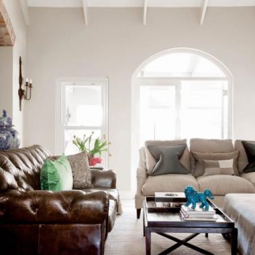 Skórzane kanapy, stolik i dużo poduszek.