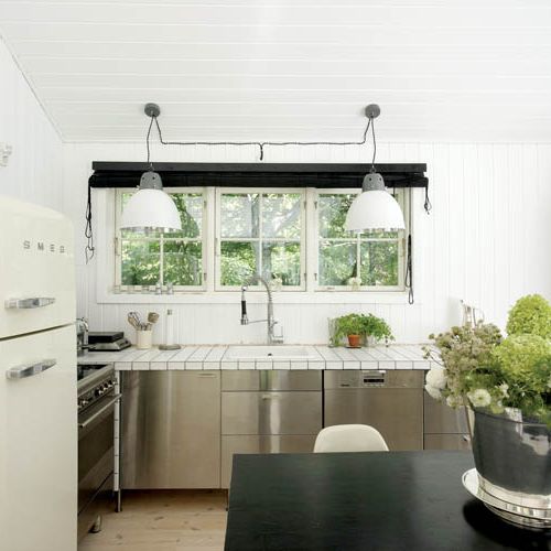 Stalowe szafki z Ikea, do tego blat z białych płytek i lampy od House Doctor.