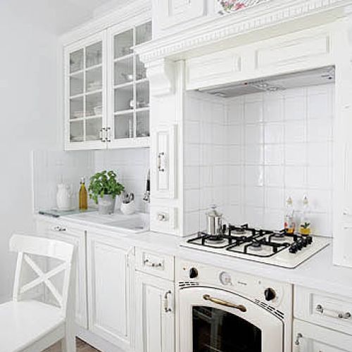 Stylizowane AGD w kuchni, krzesła z charakterystycznym dla stylu prowansalskiego skrzyżowaniem.