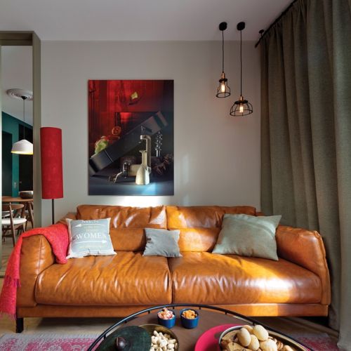 Asymetryczne zawieszenie lamp na suficie jest zrównoważone dzięki obrazowi.