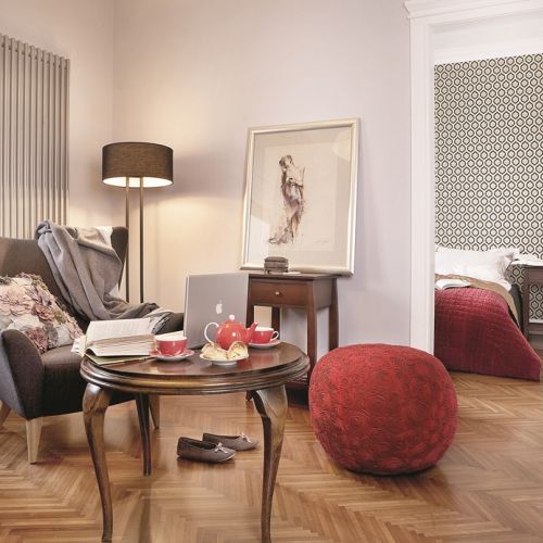 Czerwony puf przełamuje szarości we wnętrzu.