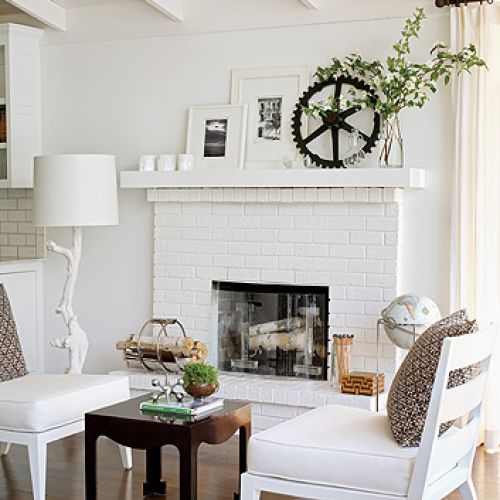 Subtelna zabawa dodatkami: na gzymsie kominka szklane ptaszki vintage i koło zębate.