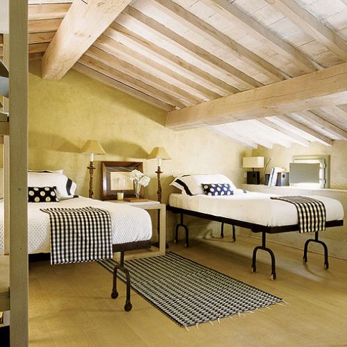 Surowe, drewniane stoły i składane krzesła inspirowane angielskimi meblami kolonialnymi solidne łoża z baldachimem obok