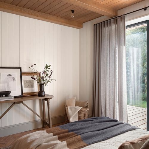 przytulna sypialnia z drewnem na ścianach i suficie