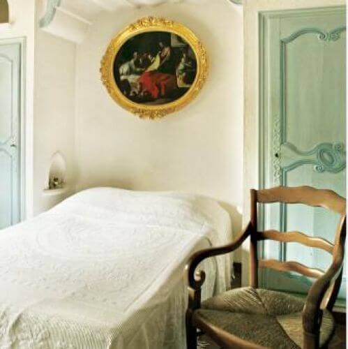 Sypialnie zdobi obraz w złotej ramie.