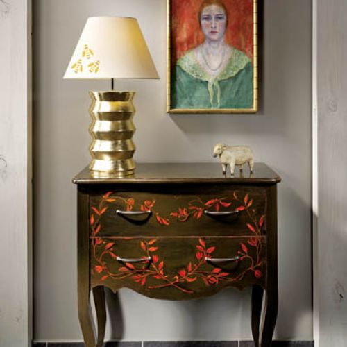 Szablon z wzorem pszczoly można wykorzystać do ozdobienia abażuru lampy. Ręcznie malowana komoda pochodzi z