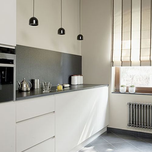 Szafki zaprojektowane przez Agnieszkę Pudlik. Granitowy blat do prostych mebli. Ten sam kamieć jest położony na ścianie.