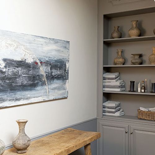 Szare meble zostały połaczone z dodatkami z naturalnego, starego drewna.