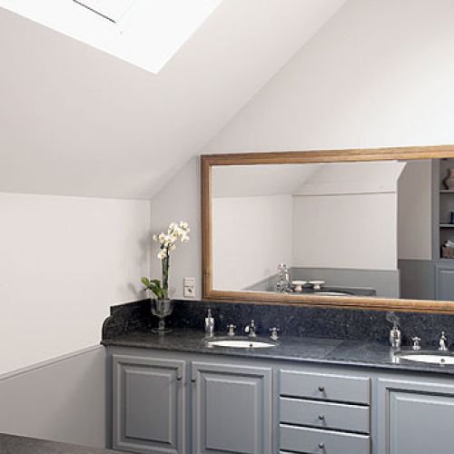 Szare meble zostały połaczone z dodatkami z naturalnego, starego drewna.