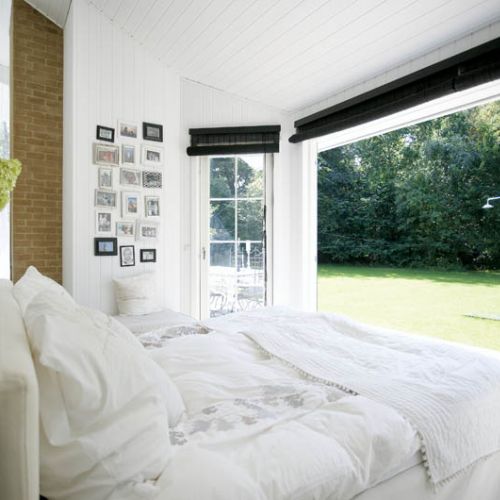 Szklana ściana sprawia, że ogród zdaje się wdzierać do wnętrza.