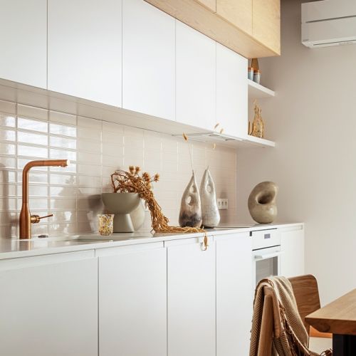 biała kuchnia z drewnem w eleganckim apartamencie