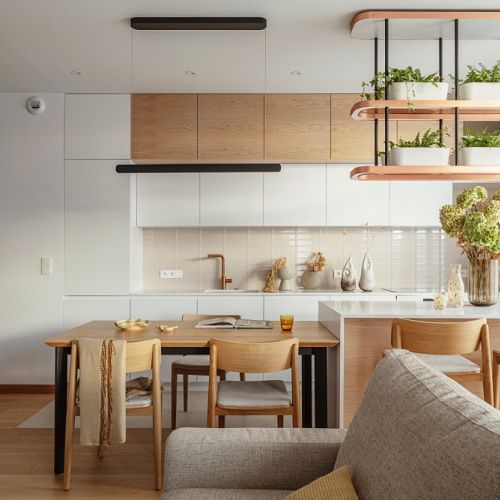 biała kuchnia z drewnem w eleganckim apartamencie