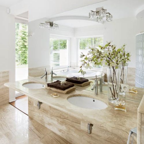 Szlachetnie i... smacznie. Łazienka wyłożona zostałą marmurem w cieplym kolorze biszkoptu.