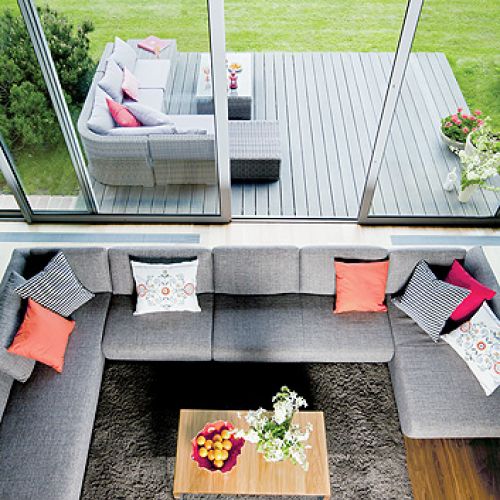 Taras i salon tworzą prawie jedno pomieszczenie dzięki ogromnym rozsuwanym oknom.