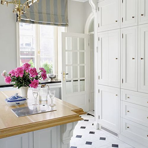 Tradycyjna kuchnia z pomysłowym trikiem. Za składanymi drzewiami wyglądającymi jak ściana szafek, ukryte są blat