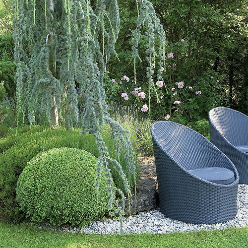 Tradycyjne rośliny, jak bukszpany i róże, połączone są z nowoczesną architekturą. Stąd stalowe elementy i chromowane donice.