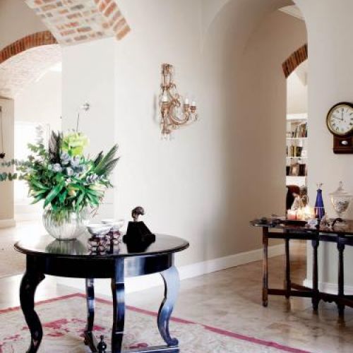 W holu stoi owalny stolik i konsola.