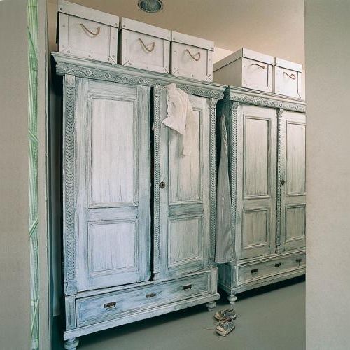 W holu stoją szafy z bielonego drewna.