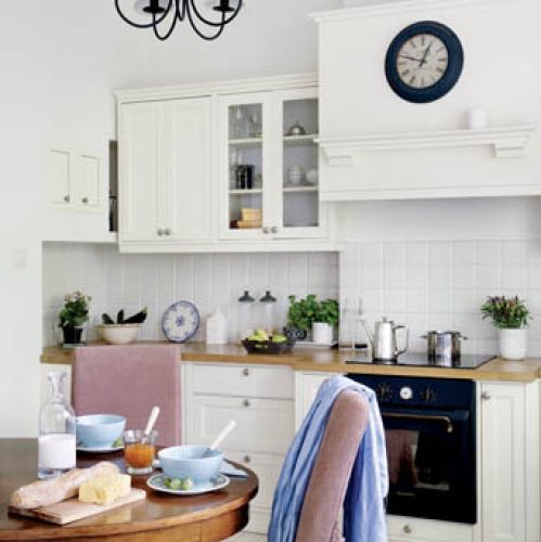 W kuchni niemal niepodzielnie panuje biel. Tylko stół i krzesła wyłamują się z kolorystycznej dyscypliny,